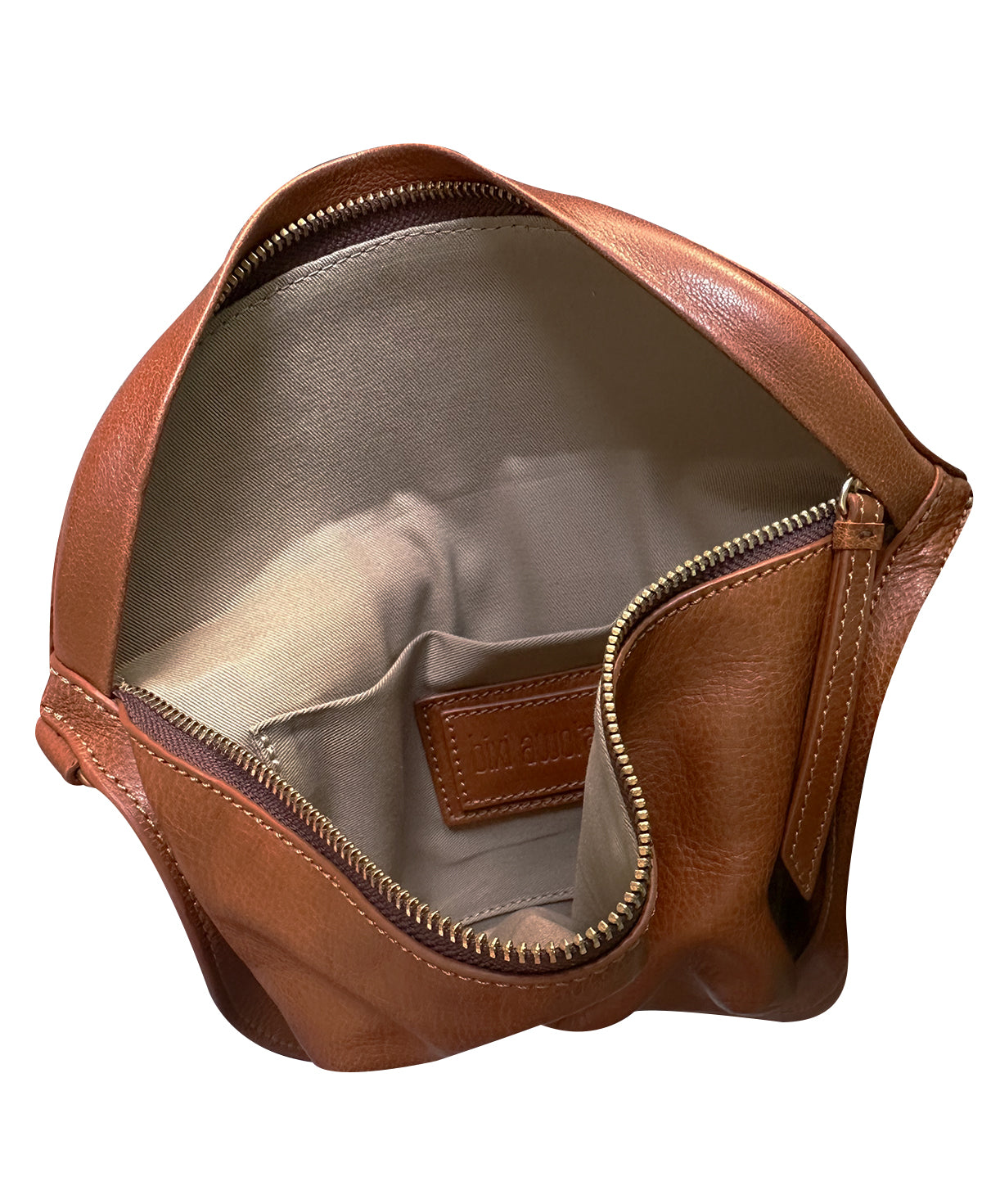 Vista del interior de la bandolera Bixi Awotan Chedron Tan mostrando el forro, bolsillo interno y etiqueta de piel.
Interior view of the Bixi Awotan Tan leather sling bag showing fabric lining, inner pocket, and brand patch.