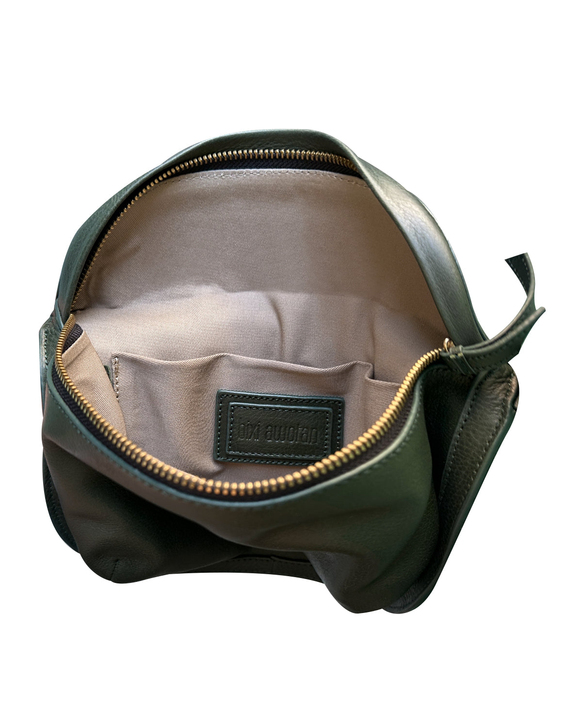 Vista del interior de la bandolera Bixi Awotan Verde Bosque mostrando el forro de tela, el bolsillo interno y la placa de la marca.  

Interior view of the Bixi Awotan Forest Green leather sling bag showing fabric lining, inner pocket, and brand patch.  